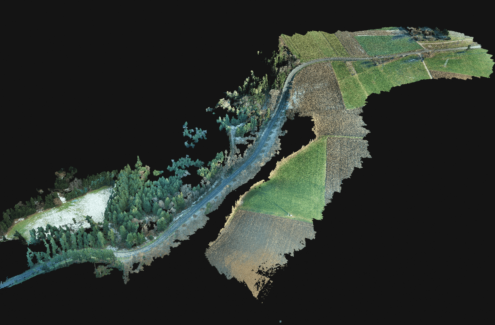 Aerial view of a road winding through a landscape with forests and agricultural fields.